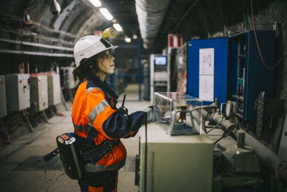 Une femme avec son équipement de protection individuel, travaille dans une installation nucléaire